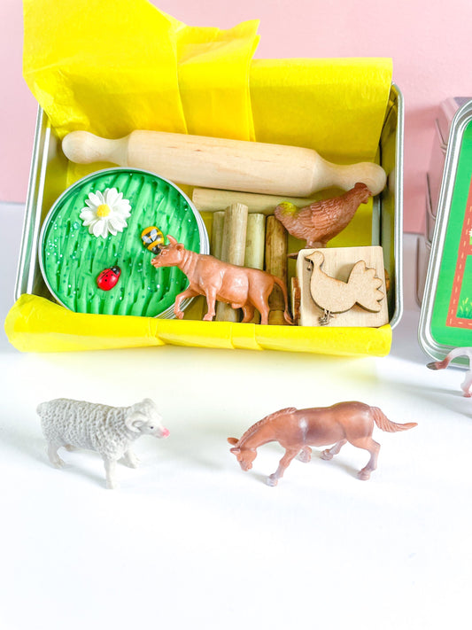 Farm Dough on the Go Activity Play Tin filled with Green Grass Farm Playdough, Farm aninmals for play scened, farm themed stamper and playdough tools and accessories wooden rolling pin. All wrapped up in a reuable metal tin with Farm stickers and wrapped in yellow tissue paper perfect for gifting.
