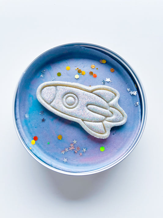 Tin filled with galactic space dough and glitter rocket for kids space and rocket themed alternative party bag fillers. Eco friendly playdough gifts