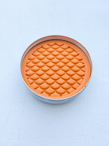 Tin of orange playdough for eco friendly party bag fillers printed with dinosaur scales