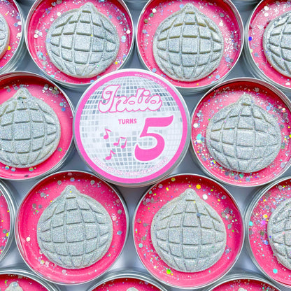Disco ball theme party pots. Tins with pink playdough topped with silver glitter disco ball cutout dough for disco themed party bag fillers. Personalised Indie turns 5 label in the middle