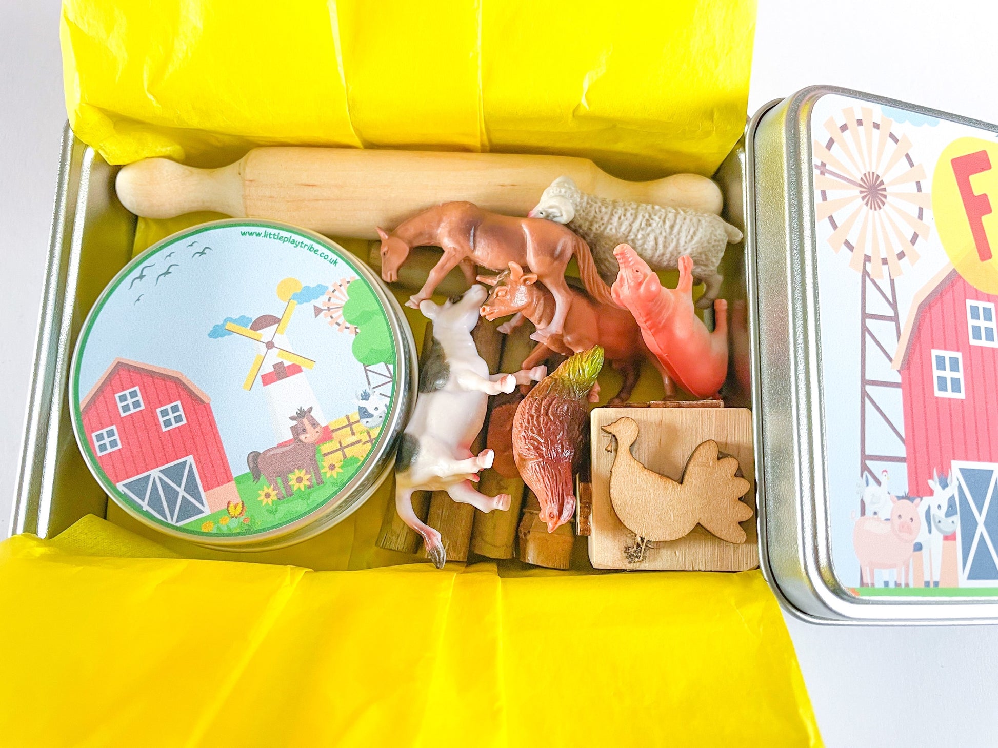 Farm Dough on the Go Activity Play Tin filled with Green Grass Farm Playdough, Farm animals for play scened, farm themed stamper and playdough tools and accessories wooden rolling pin. All wrapped up in a reuable metal tin with Farm stickers and wrapped in yellow tissue paper perfect for gifting.