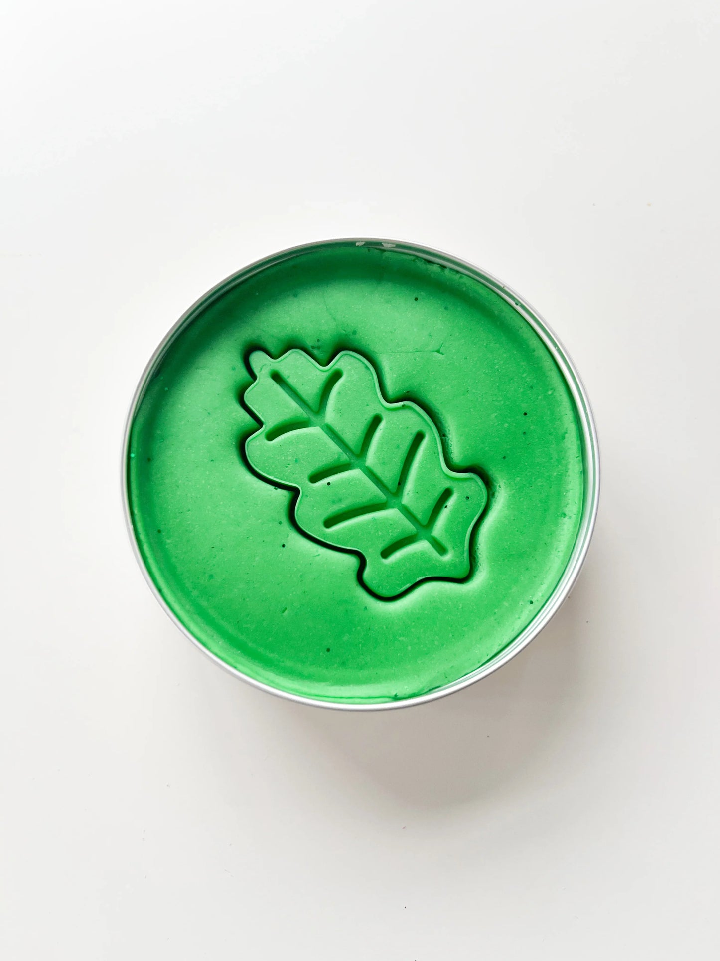 Forest theme party bag filler. Tin of green playdough with leaf shaped playdough inprint