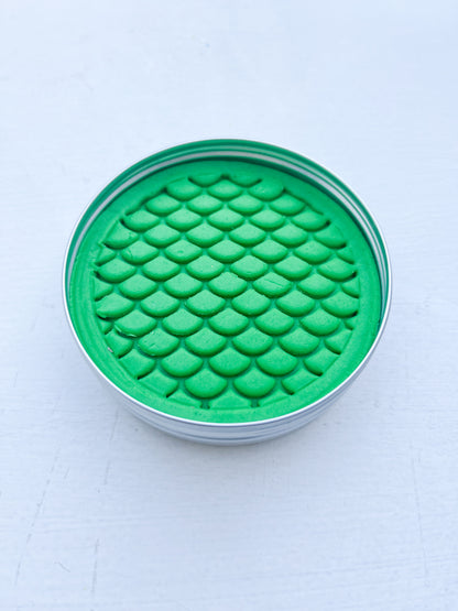 Tin of green playdough for eco friendly party bag fillers printed with dinosaur scales