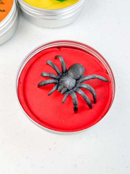 Insect Themed Sensory Playdough Pots for Alternative Party Bag Fillers. Eco friendly, handmade playdough in a mix of colours with reptile animal characters on top. One tin of red playdough with spider figure on top