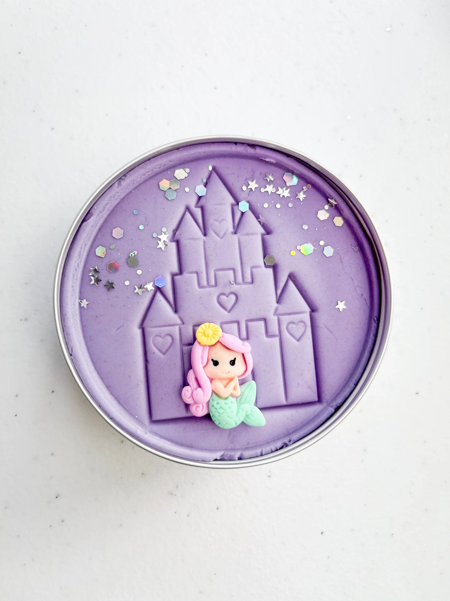 Tin of purple playdough imprinted with castle and princess figure for princess themed kids birthday party favours. Eco friendly and plastic free alternative party bag fillers