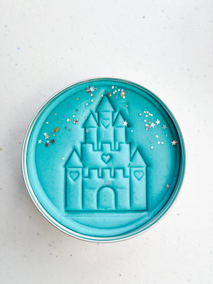 Tin of blue playdough imprinted with castle for princess themed kids birthday party favours. Eco friendly and plastic free alternative party bag fillers