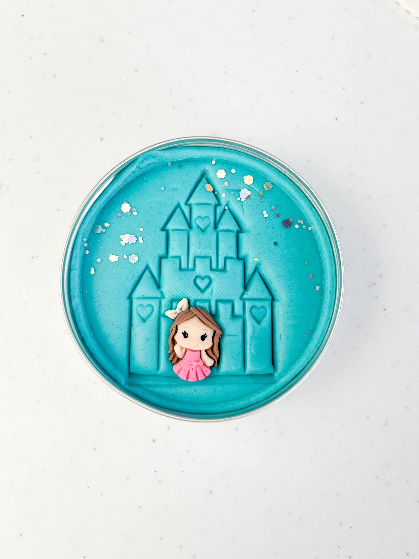 Tin of blue playdough imprinted with castle and princess figure for princess themed kids birthday party favours. Eco friendly and plastic free alternative party bag fillers
