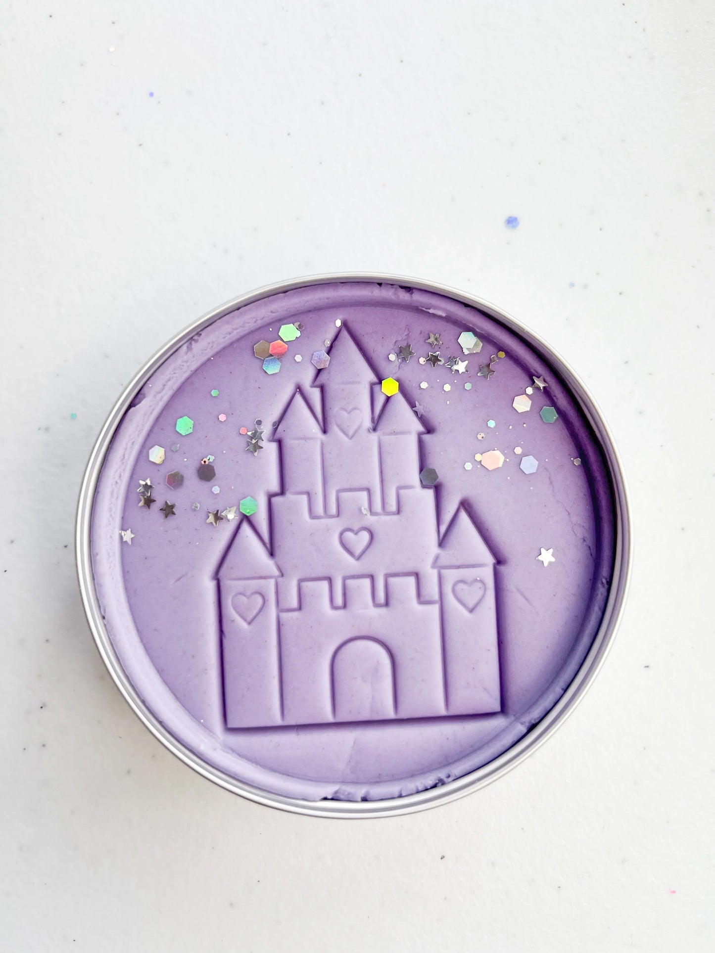 Tin of purple playdough imprinted with castle for princess themed kids birthday party favours. Eco friendly and plastic free alternative party bag fillers