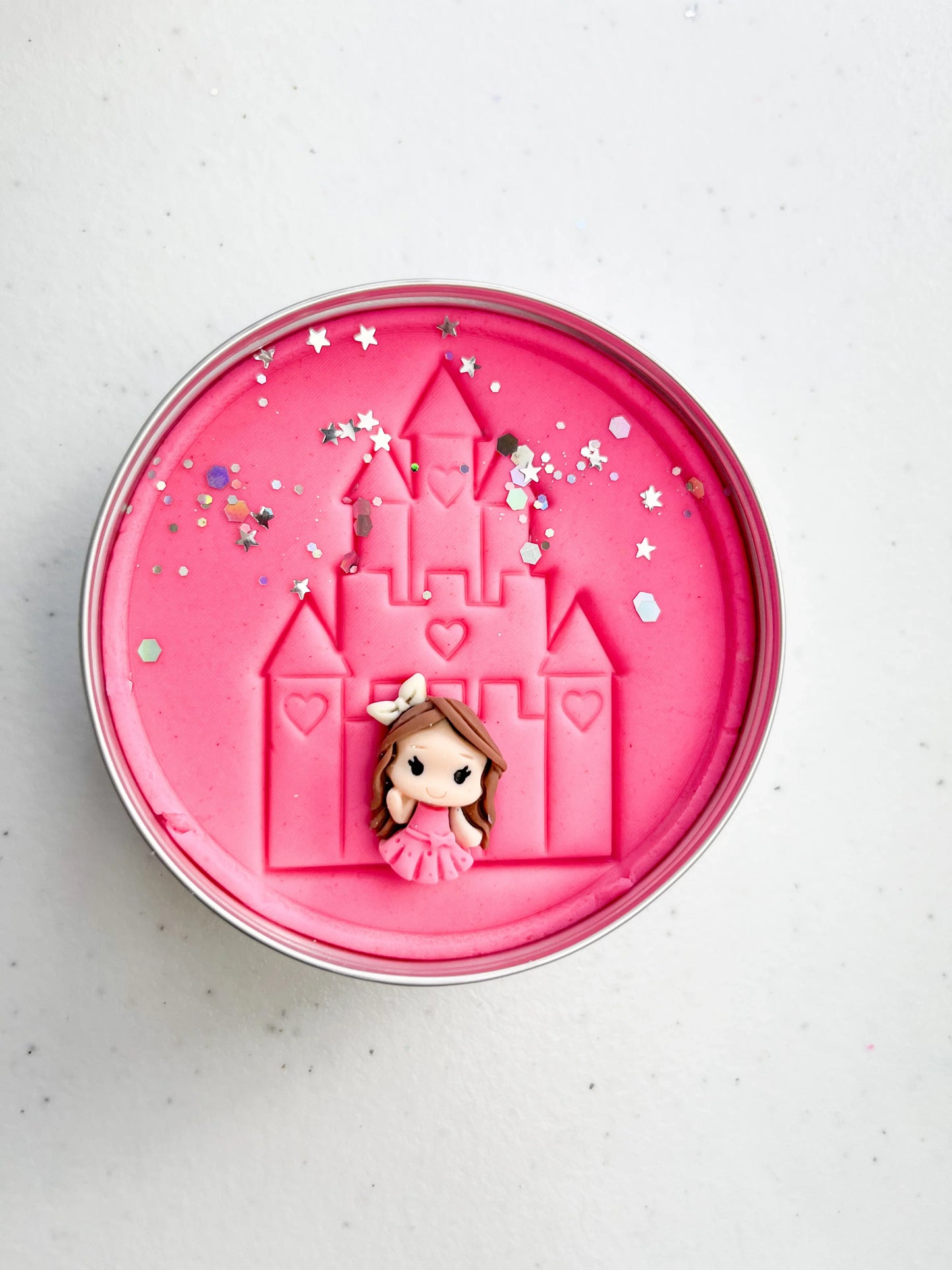 Tin of pink playdough imprinted with castle and princess figure for princess themed kids birthday party favours. Eco friendly and plastic free alternative party bag fillers
