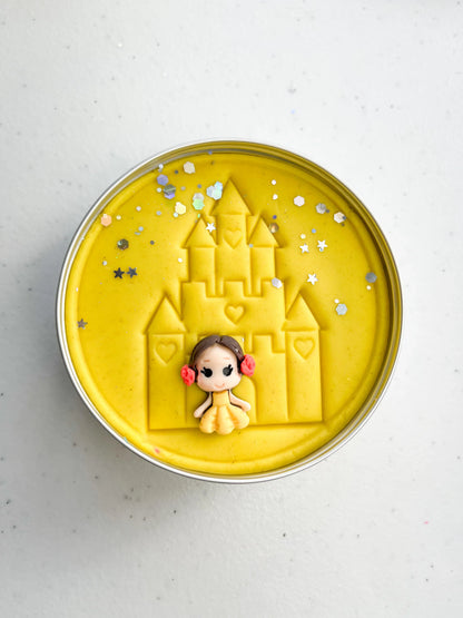 Tin of yellow playdough imprinted with castle and princess figure for princess themed kids birthday party favours. Eco friendly and plastic free alternative party bag fillers