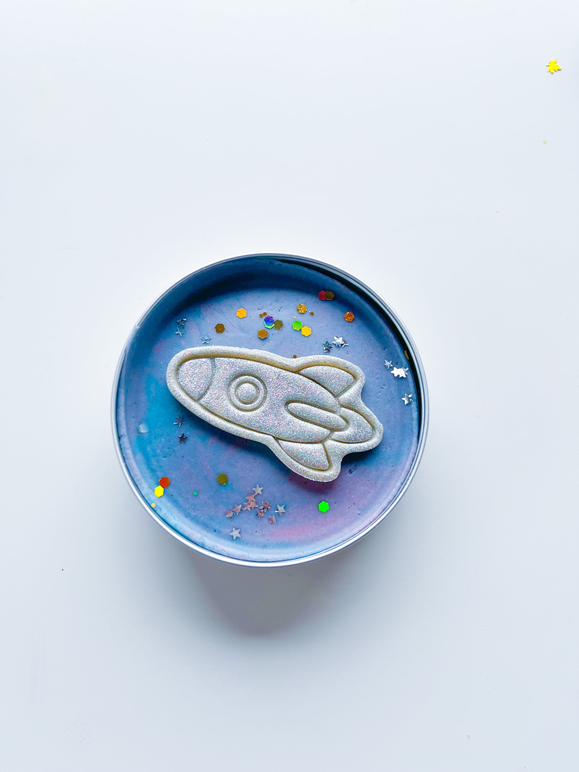 Tin filled with galactic space dough and glitter rocket for kids space and rocket themed alternative party bag fillers. Eco friendly playdough gifts