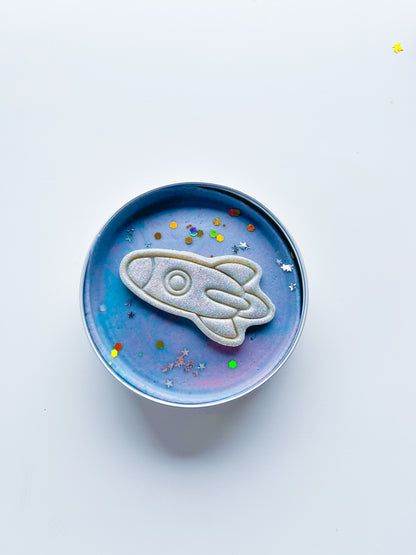 Tin filled with galactic space dough and glitter rocket for kids space and rocket themed alternative party bag fillers. Eco friendly playdough gifts
