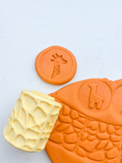 plastic free eco roller with safari themed imprints showing animal themed shapes on orange playdough with this tool